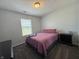 A simple bedroom with a bed, carpet, dresser, and a window letting in natural light at 1406 Bigleaf Cir, Sheridan, IN 46069