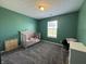 This bedroom features a crib, window, carpet, and green walls perfect for a Bedroom or room at 1406 Bigleaf Cir, Sheridan, IN 46069