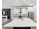 Modern kitchen with a large island, stainless steel appliances and living room fireplace in the background at 1406 Linden St, Indianapolis, IN 46203