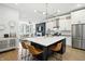 A modern kitchen with island seating, stainless appliances and a living room in the background at 1406 Linden St, Indianapolis, IN 46203