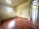 A bedroom with wood-look floors, light walls, two closets and natural light from a window at 1509 S Rural St, Indianapolis, IN 46203