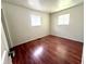 Bright bedroom featuring wood-look floors, two windows, and neutral wall colors at 1509 S Rural St, Indianapolis, IN 46203