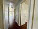 Hallway view with doors on either side and wood-look floors and neutral walls at 1509 S Rural St, Indianapolis, IN 46203