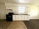 Well-lit kitchen with white cabinets, modern appliances, and two-toned flooring at 1509 S Rural St, Indianapolis, IN 46203