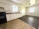 Well-lit kitchen with white cabinets, modern appliances, and two-toned flooring at 1509 S Rural St, Indianapolis, IN 46203