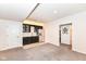 Basement bar area with modern cabinetry, stainless steel refrigerator, and adjacent bonus room at 16283 Spring Bank Ct, Fishers, IN 46040