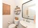 Stylish powder room with floating shelves, circular mirror, and pedestal sink at 16283 Spring Bank Ct, Fishers, IN 46040