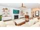 Inviting living room with fireplace, floating shelves, and a modern ceiling fan at 16283 Spring Bank Ct, Fishers, IN 46040