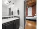 Stylish bathroom featuring a sleek vanity with a black cabinet and unique backsplash, and a bedroom view adding appeal at 207 S Meridian St # 2F, Indianapolis, IN 46225