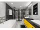 Modern bathroom with double sinks, unique yellow cabinetry, a soaking tub, and separate glass shower at 207 S Meridian St # 2F, Indianapolis, IN 46225