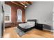 Inviting bedroom with exposed brick walls, large windows, and modern furnishings for a comfortable retreat at 207 S Meridian St # 2F, Indianapolis, IN 46225