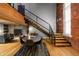 Spacious dining room featuring hardwood floors and a staircase with exposed brick wall at 207 S Meridian St # 2F, Indianapolis, IN 46225