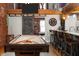 Inviting game room features a billiard table, exposed brick, timber beams, and a modern bar area with seating at 207 S Meridian St # 2F, Indianapolis, IN 46225