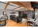 Living room with wooden beams, wood floors, and a comfortable dark gray sectional sofa at 207 S Meridian St # 2F, Indianapolis, IN 46225
