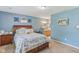 Bright bedroom with calming blue walls and a comfortable bed featuring a floral-patterned quilt at 2127 Yosemite Dr, Lebanon, IN 46052