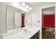 Bathroom with a white sink and mirror, showing a glimpse into a red room at 248 Eastview Dr, Bargersville, IN 46106