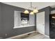 A dining room featuring a modern light fixture, gray walls, window with black shade, and wood laminate flooring at 248 Eastview Dr, Bargersville, IN 46106