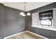 A dining room featuring a modern light fixture, gray walls, and a window with a dark-colored shade at 248 Eastview Dr, Bargersville, IN 46106