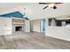 A living room featuring a brick fireplace, built in shelving, wood laminate flooring, ceiling fan, and white walls at 248 Eastview Dr, Bargersville, IN 46106