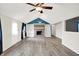 A living room featuring a brick fireplace, built in shelving, wood laminate flooring, ceiling fan, and white walls at 248 Eastview Dr, Bargersville, IN 46106