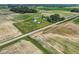 Aerial view of country property with multiple outbuildings and a home, surrounded by green fields at 26735 Six Points Rd, Sheridan, IN 46069