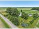 A home sits amongst mature trees and professional landscaping in an aerial view at 26735 Six Points Rd, Sheridan, IN 46069