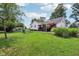 A spacious backyard with a lush green lawn and fire pit seating area at 26735 Six Points Rd, Sheridan, IN 46069