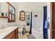 Traditional bathroom featuring vanity, subway tile, toilet and tub-shower combination with blue curtain at 26735 Six Points Rd, Sheridan, IN 46069