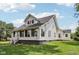 Exterior angled view of a two-story home featuring a large sunroom addition and well-kept lawn at 26735 Six Points Rd, Sheridan, IN 46069