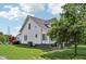 Side view of a white two-story house with a well-maintained lawn and a mature tree providing shade at 26735 Six Points Rd, Sheridan, IN 46069