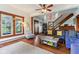 Open-concept living room has hardwood floors, bright windows, comfortable seating, and open staircase at 26735 Six Points Rd, Sheridan, IN 46069