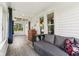 Cozy sunroom with wood floors, gray daybed and a view of the outdoors through large windows at 26735 Six Points Rd, Sheridan, IN 46069