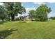 Expansive yard featuring mature trees and garden space surrounding a white two-story home at 26735 Six Points Rd, Sheridan, IN 46069