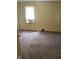A comfy bedroom with neutral carpet, a bright window, and classic trim at 3059 5Th E Ave, Indianapolis, IN 46221