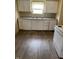 Functional kitchen featuring white appliances, ample counter space, and wood-look flooring at 3059 5Th E Ave, Indianapolis, IN 46221
