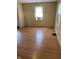 A bright living room with wood paneling, wood-look floors, and ample natural light from two windows at 3059 5Th E Ave, Indianapolis, IN 46221
