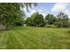 Large, well-maintained backyard with a lush lawn and mature trees at 3818 S Creekside Dr, New Palestine, IN 46163