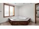 Bathroom featuring corner soaking tub with tile surround and wooden cabinetry at 3818 S Creekside Dr, New Palestine, IN 46163