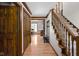 Spacious foyer featuring hardwood floors, wood trim, coat closet, and staircase to the upper level at 3818 S Creekside Dr, New Palestine, IN 46163