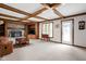 Large living room with stone fireplace, wood beams, and built-in shelving at 3818 S Creekside Dr, New Palestine, IN 46163