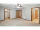 Large bedroom features neutral carpeting, ceiling fan, and multiple doors to closets and bathrooms at 3920 Oak Harbor Ln, Indianapolis, IN 46237