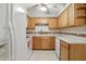 Kitchen featuring wooden cabinets, tile backsplash, white appliances, white counters and a ceiling fan at 3920 Oak Harbor Ln, Indianapolis, IN 46237