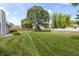 Lush backyard featuring mature trees, a pristine lawn, and a rustic wooden fence for added charm at 421 E Delaware St, Fortville, IN 46040