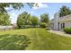Expansive backyard featuring a well-kept lawn, mature trees, and a charming picket fence at 421 E Delaware St, Fortville, IN 46040