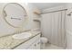 Bathroom featuring a sleek vanity with granite countertops and a round mirror at 421 E Delaware St, Fortville, IN 46040