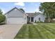 Charming single-story home with blue siding, brick accents, well-manicured lawn and an attached two car garage at 421 E Delaware St, Fortville, IN 46040