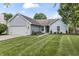 Charming single-story home with blue siding, brick accents, well-manicured lawn and an attached two car garage at 421 E Delaware St, Fortville, IN 46040