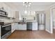 Modern kitchen with stainless steel appliances, white cabinets, and stylish lighting at 421 E Delaware St, Fortville, IN 46040