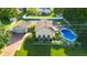 An aerial view of a lovely home with pool, brick driveway, tennis court and green backyard at 4224 River Rd, Columbus, IN 47203