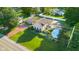 Stunning aerial view of a home with a pool, deck, tennis court, beautiful landscaping and a detached garage at 4224 River Rd, Columbus, IN 47203